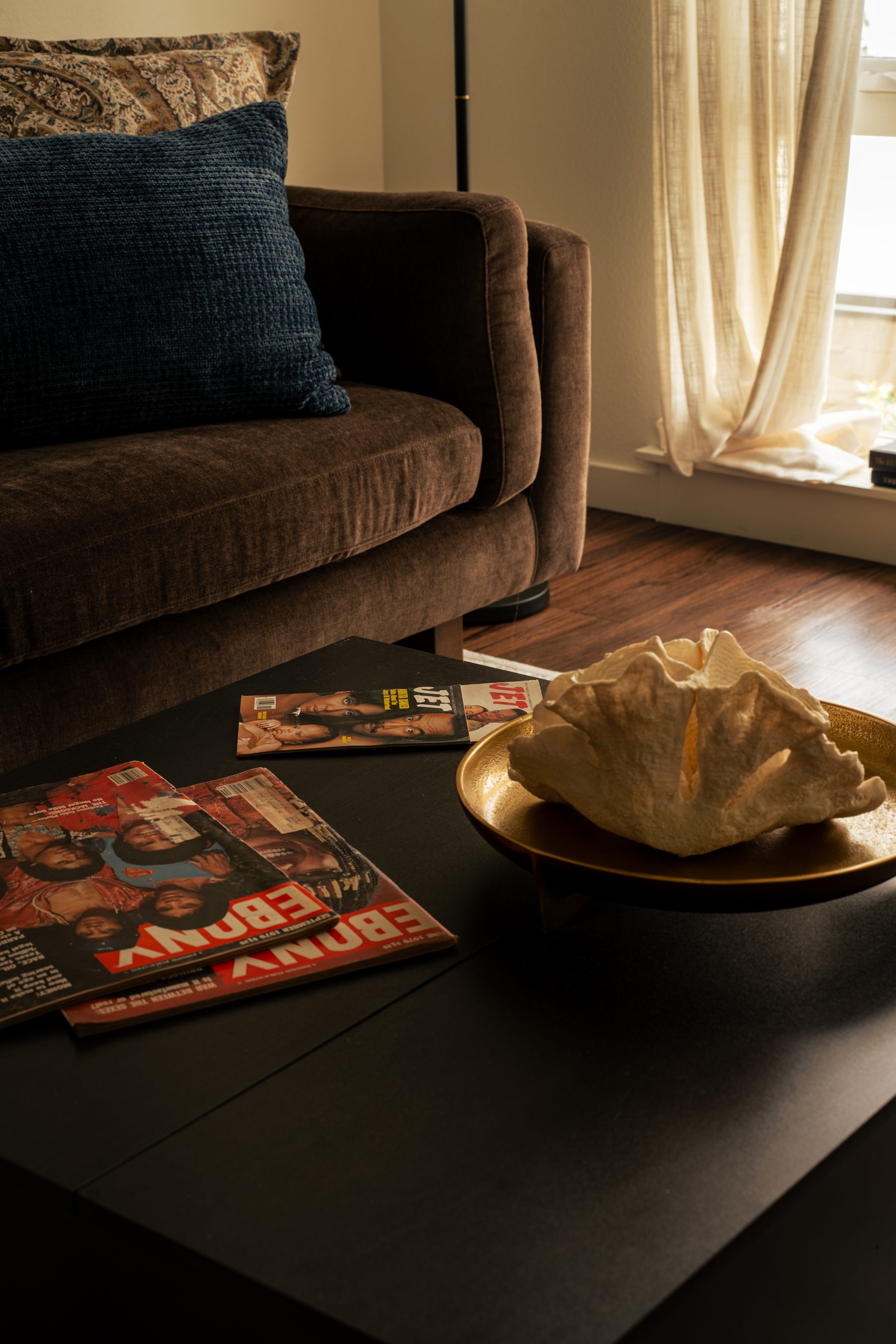 Vintage EBONY and JET magazines beside a coral shell on a gold plate